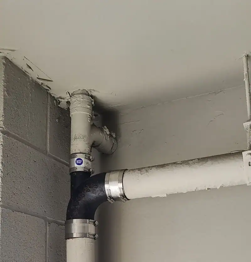 New drain elbow spliced into an older line with shielded no-hub couplings on an Anaheim job
