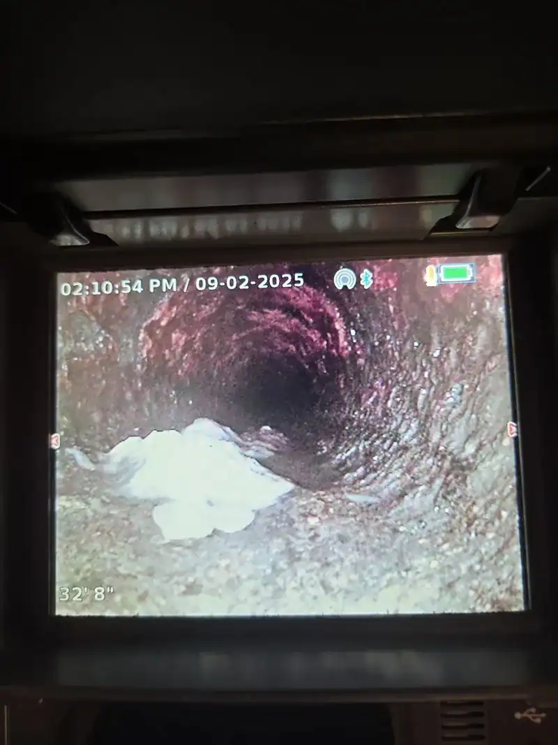Sewer camera monitor showing mineral deposits inside a Fountain Valley lateral at 32 feet 8 inches