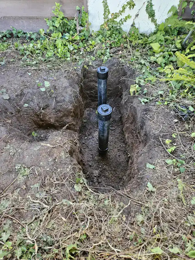 New two-way sewer cleanout risers installed in an open excavation on a Fountain Valley sewer repair
