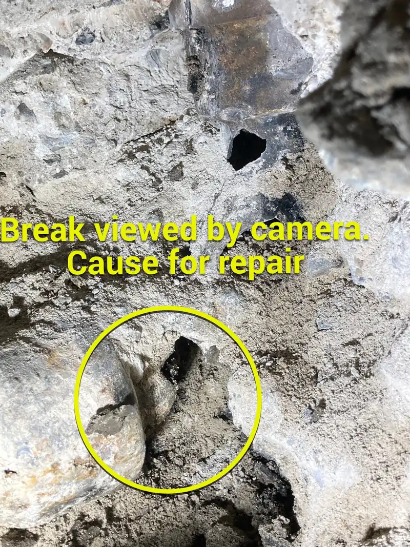 Broken sewer drain exposed under the slab on a Garden Grove sewer repair, with the break circled