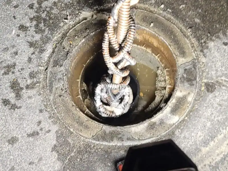 Drain cable fed into a floor drain to clear a sewer backup