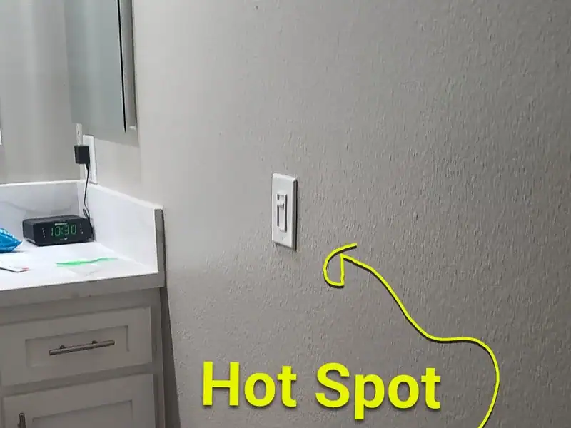 Warm spot marked on a bathroom wall during a hot water leak search