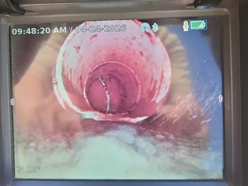 Sewer camera monitor showing a cracked clay pipe at 7 feet 10 inches from the access point